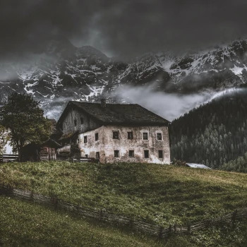 An old home on a hill, engulfed in fog.