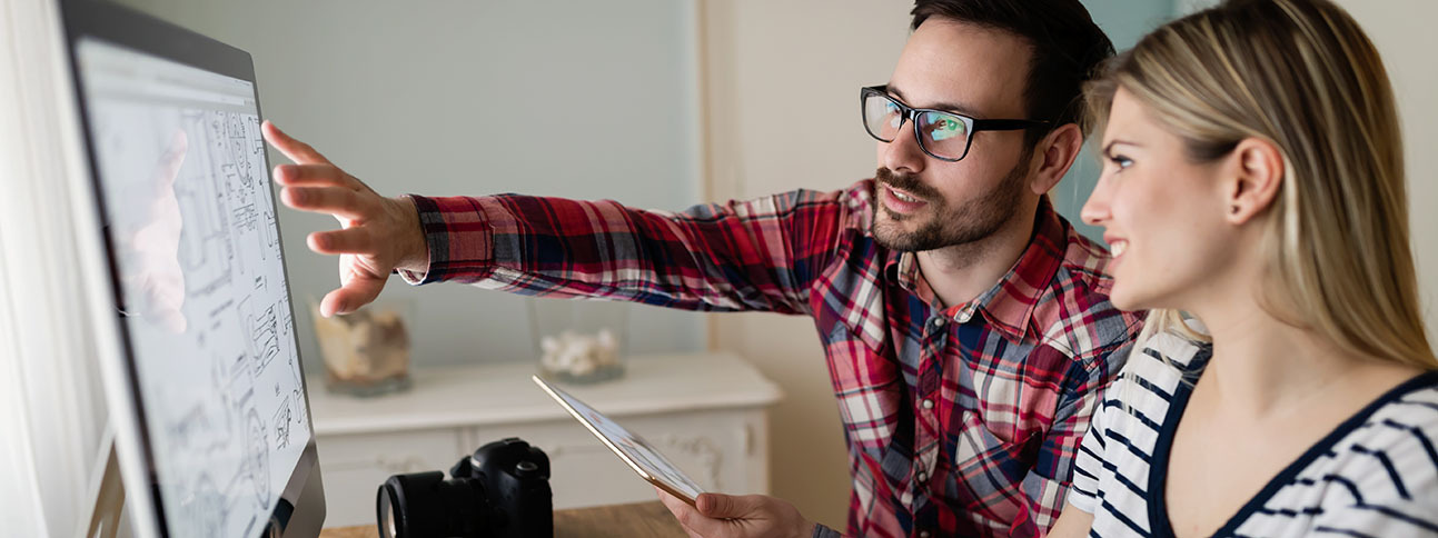 Photo of 2 individuals performing a user experience analysis pointing at a computer screen