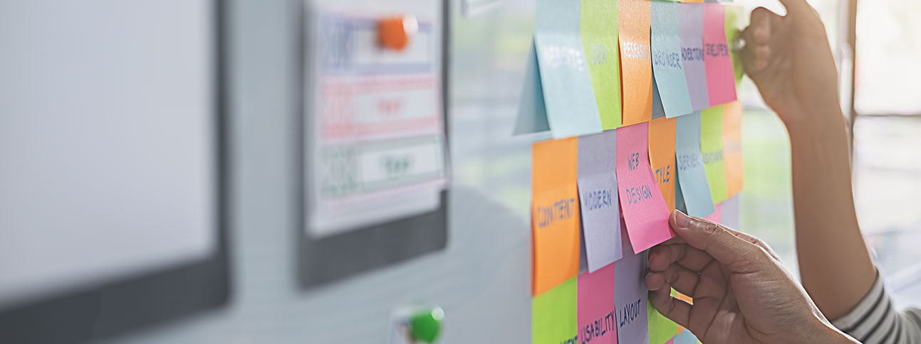 Multicolored post-it-notes arranged on a whiteboard at an angle