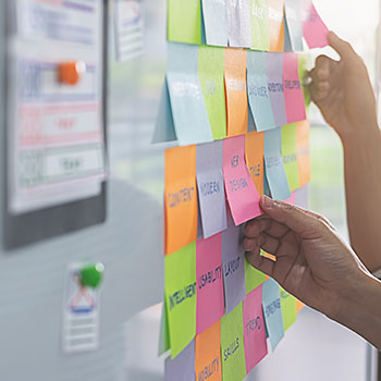 Multicolored post-it-notes arranged on a whiteboard at an angle