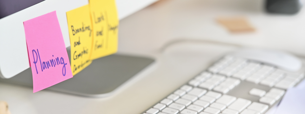 Computer monitor with a sticky note that reads planning