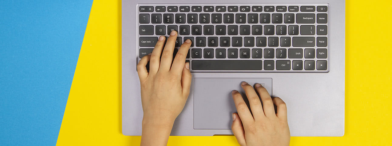 Close-up of hands typing on a laptop