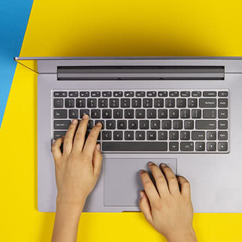 Close-up of hands typing on a laptop