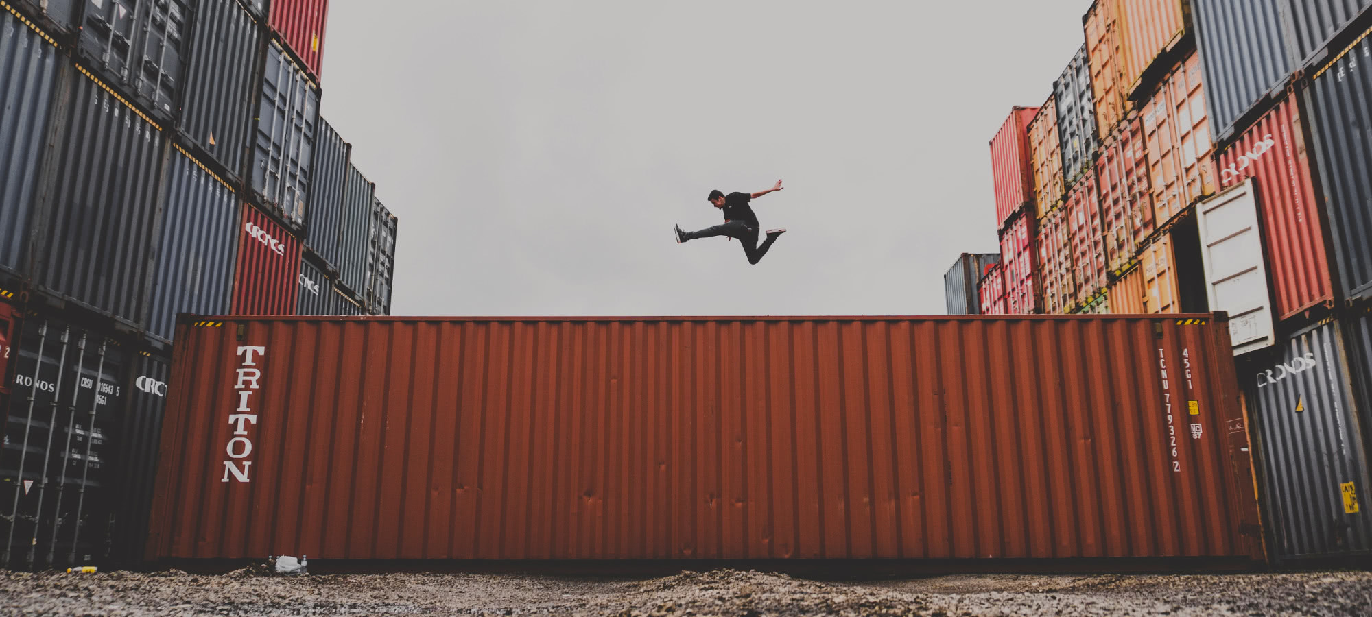 man jumping over shipping container