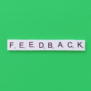 A green background with Scrabble tiles spelling out the word feedback.