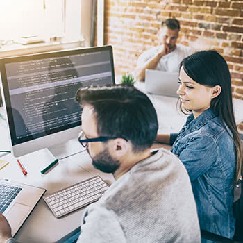 Teammates sitting together and looking at code