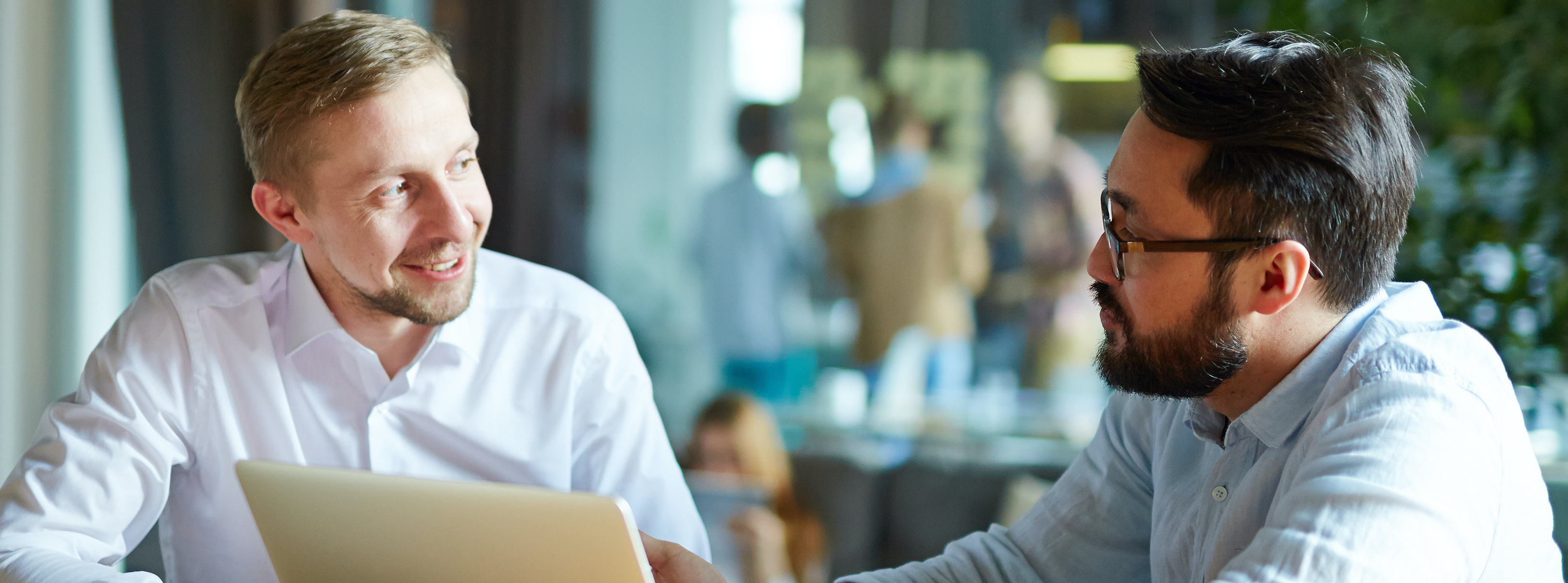 A person seeking mastery, collaborating with their teammate on an open laptop