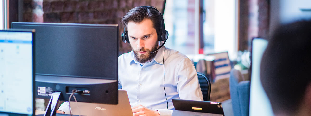 Man on computer with headset