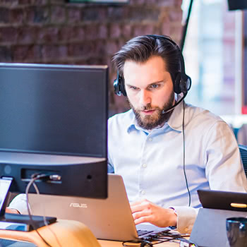 Man on computer with headset