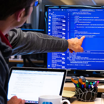 Teammate looking at code and pointing at screen